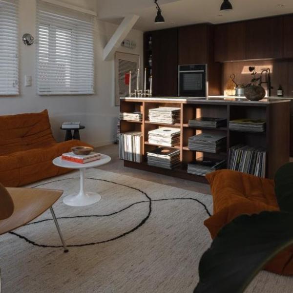 Open-plan living room in mid-century decor style with a light carpet featuring a black line design.